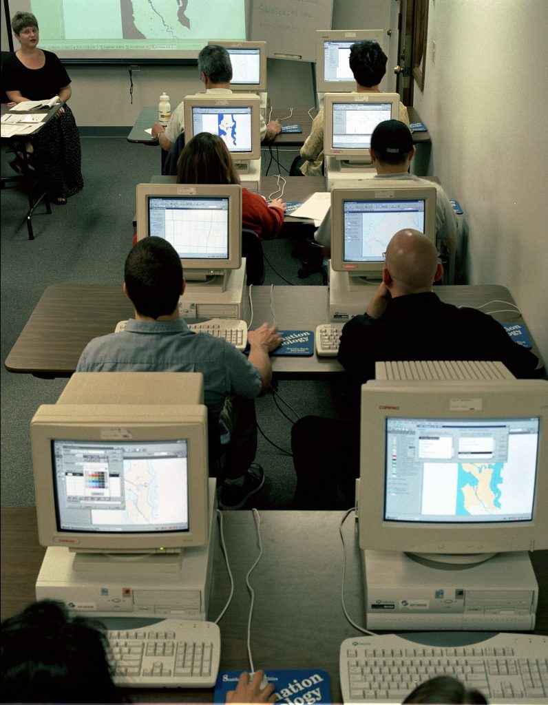 adults learning computer skills in a training classroom