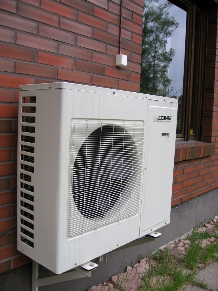 Heat Pumps vs Traditional Heating: The Real Costs An air source heat pump unit installed outside a house