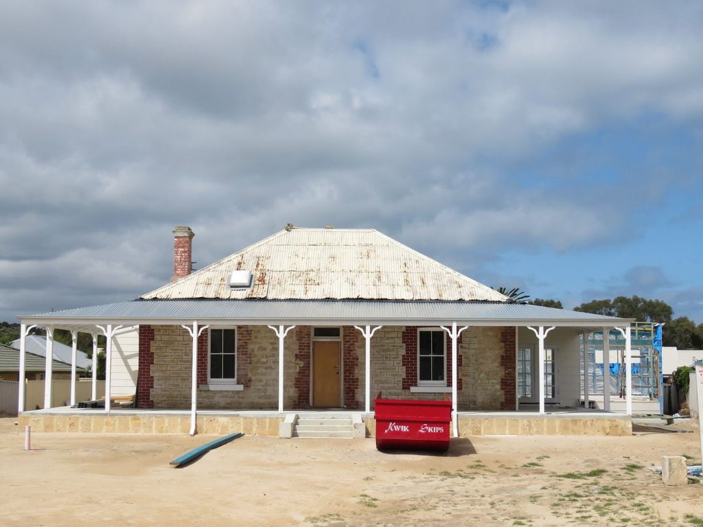 Home Renovation Mistakes That Cut Property Value A worker renovating the interior of a house with tools and materials